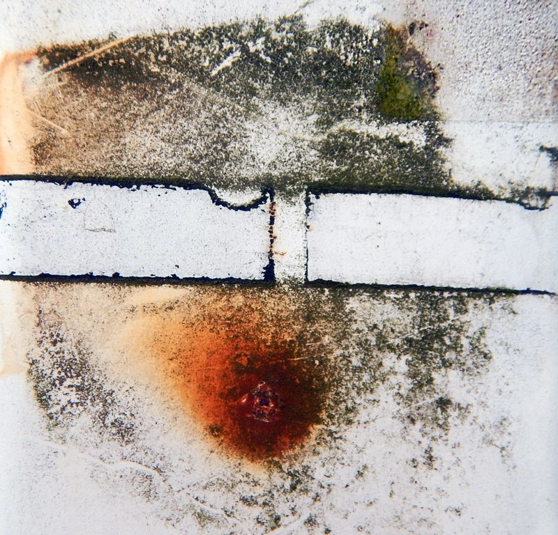 Eroded tape & rust design on a white post.